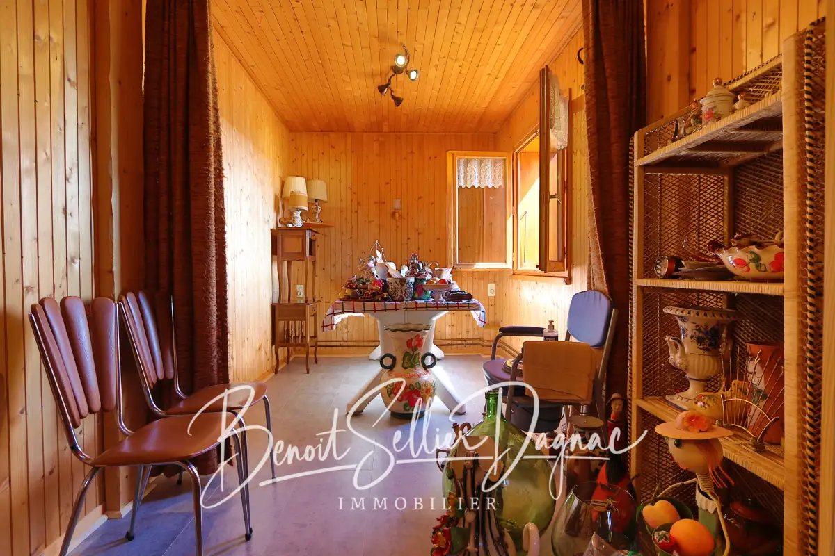 Salle à manger avec murs en bois dans maison à Cuvat