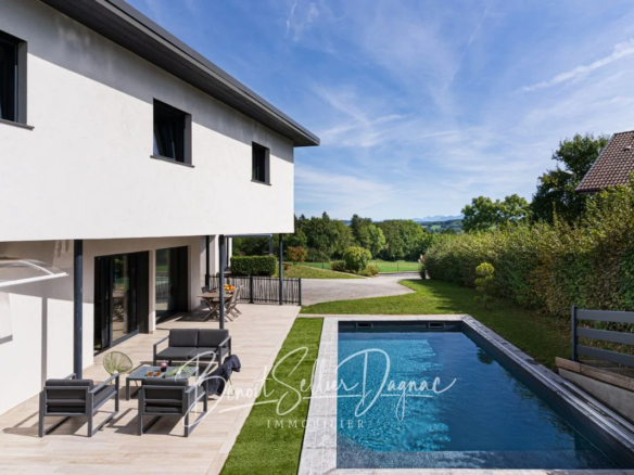 Piscine en bordure de terrasse avec vue sur la verdure à Cuvat
