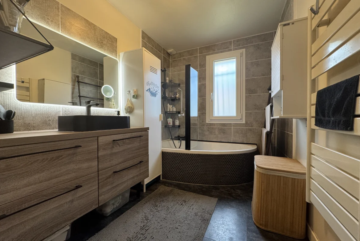 Salle de bains avec baignoire d angle et meuble vasque dans une maison à Annecy-le-Vieux