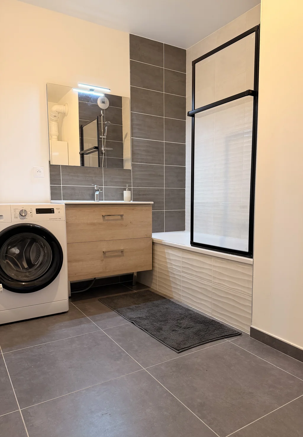 Salle de bains moderne avec baignoire dans un appartement récent à Cuvat