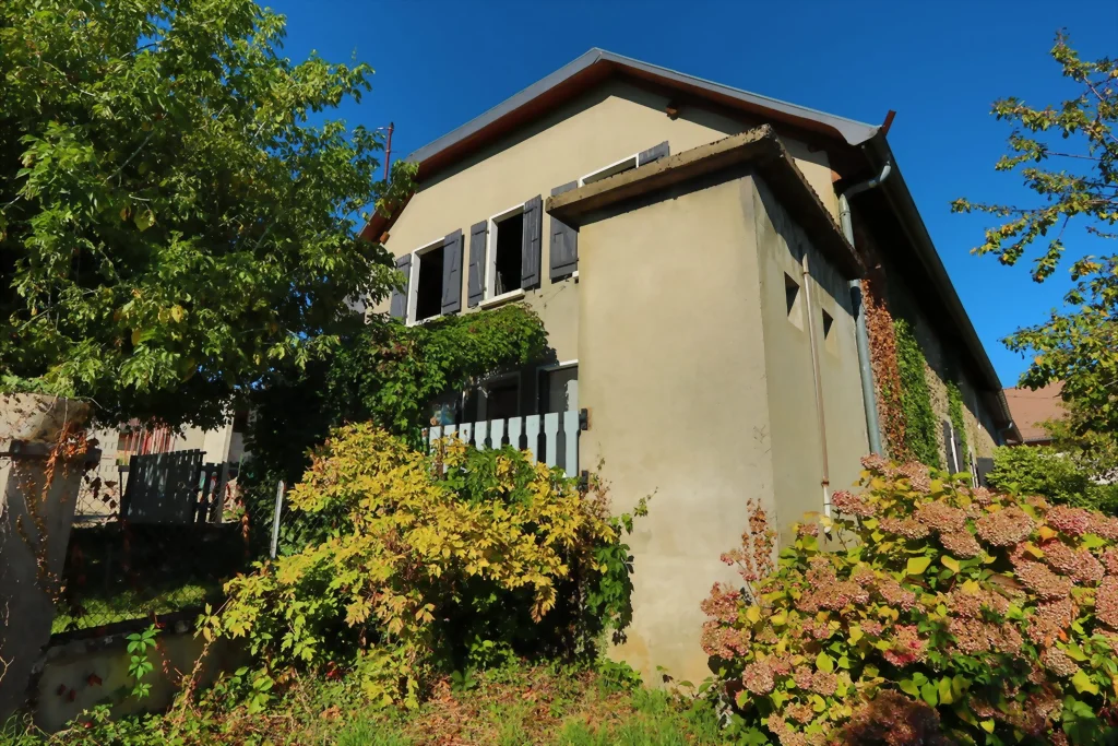 Façade côté pignon et jardin fleuri d’une maison à rénover à Mésigny