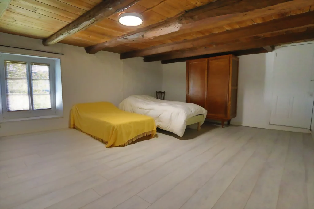 Chambre généreuse avec poutres apparentes et parquet clair